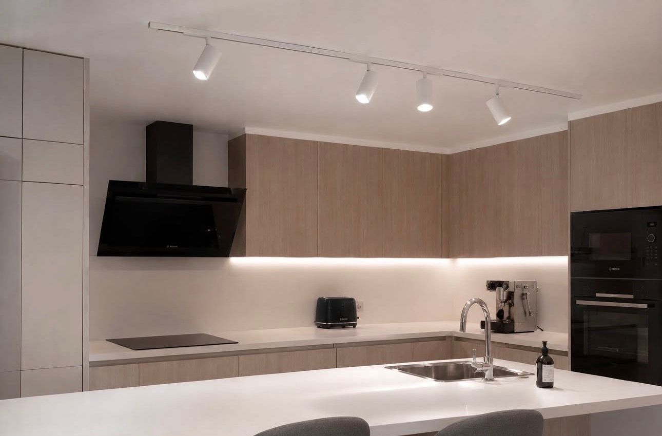 Cocina con carril de focos y tira LED bajo los muebles